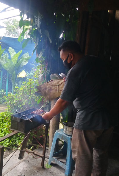 penjual sate mengipasi daging kambing